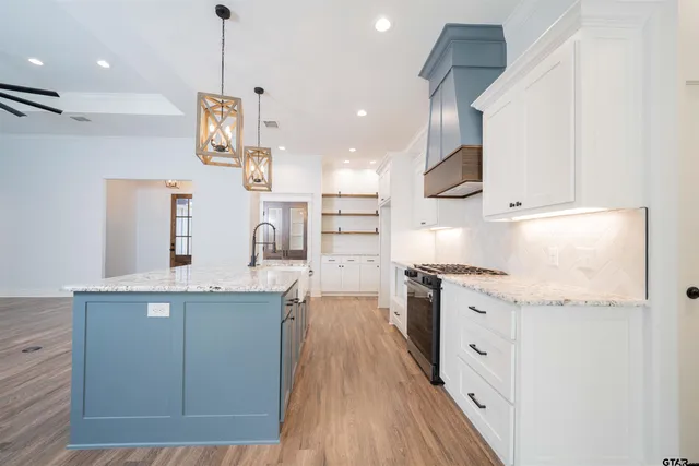 a kitchen with stainless steel appliances granite countertop a sink a stove and a refrigerator