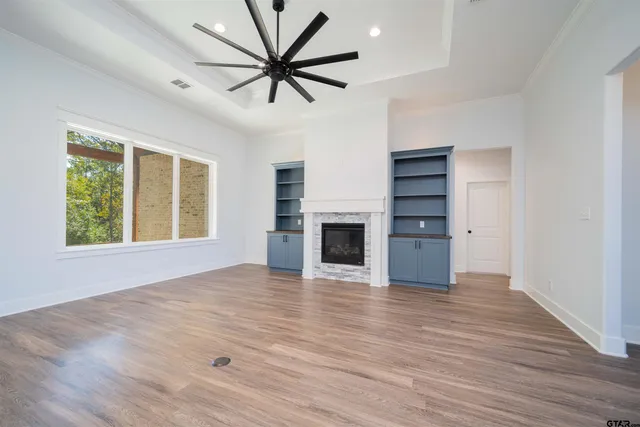 an empty room with windows and a fireplace