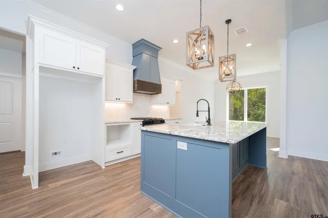 a kitchen with a sink cabinets and wooden floor