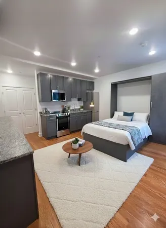 a bedroom with a bed and a view of kitchen
