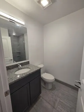 a bathroom with a granite countertop sink and a mirror