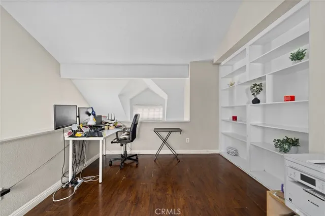 a view of a workspace with furniture and a wooden floor