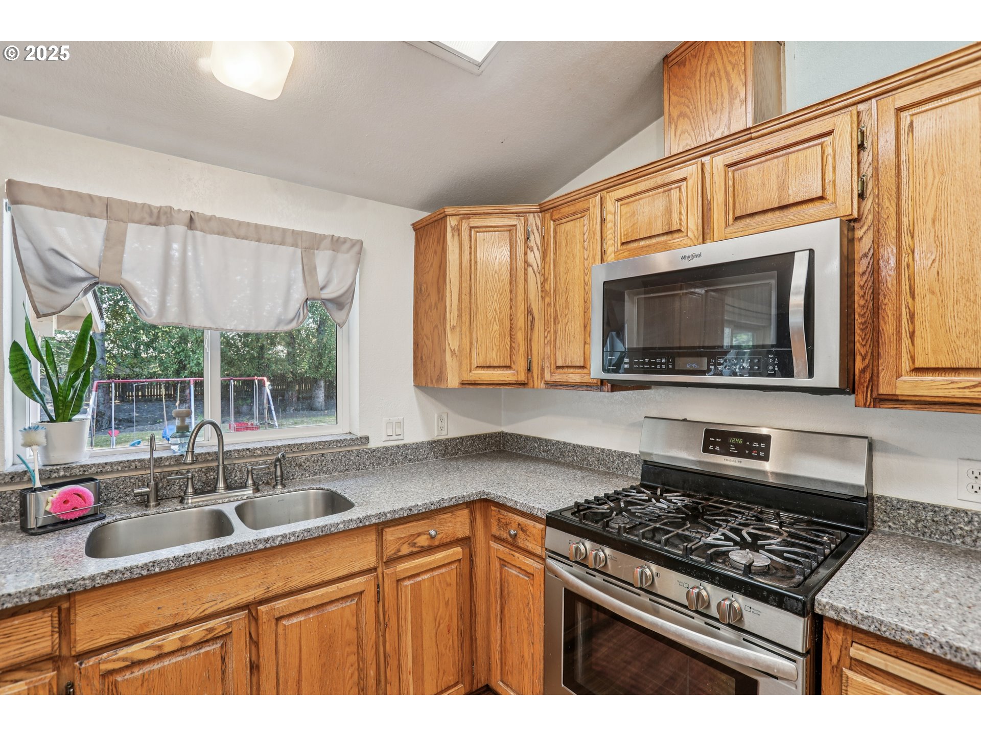 914 James Street Independence, OR 97351 - Photo 17 of 48 a kitchen with stainless steel appliances a sink a stove cabinets and a window