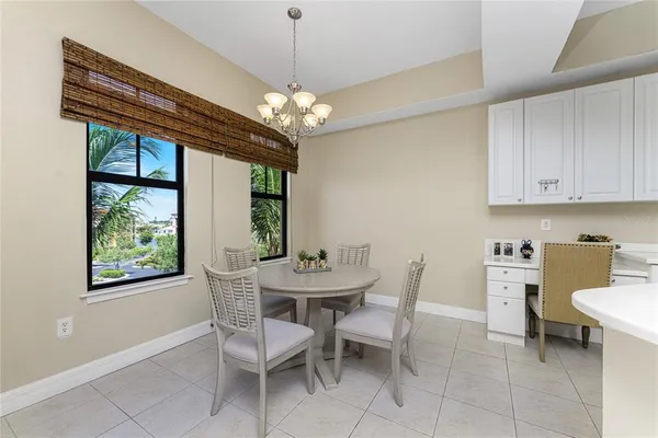 a view of a dining room with furniture a chandelier and window
