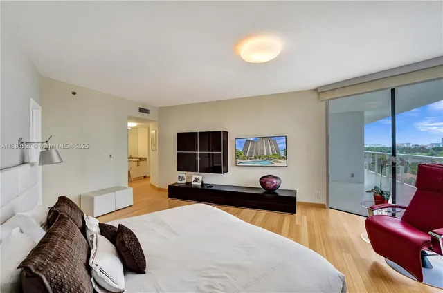 a view of a hallway with wooden floor and a living room