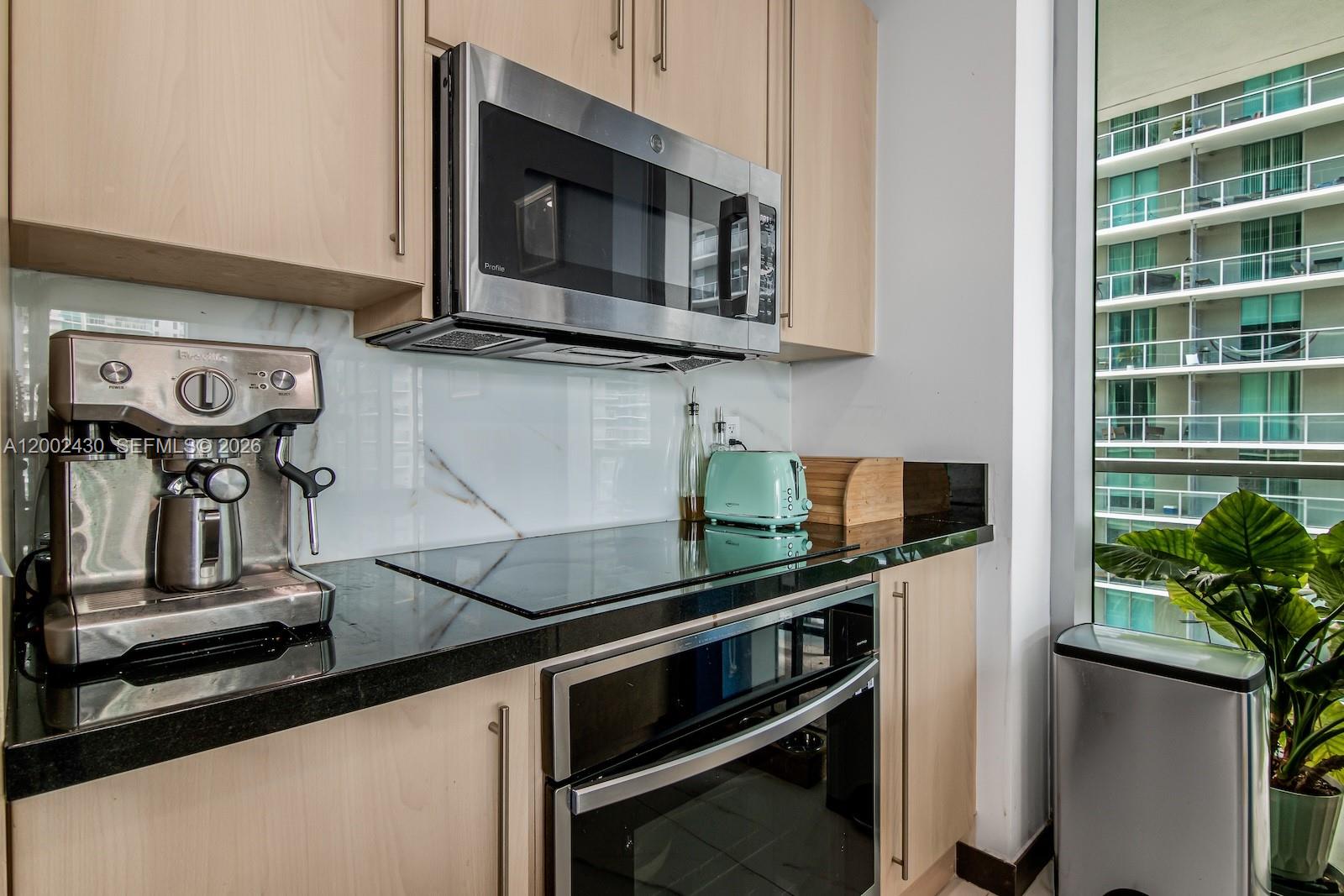 79 Southwest 12th Street, Unit 2107S Miami, FL 33130 - Photo 11 of 47 a kitchen with stainless steel appliances a sink stove and microwave