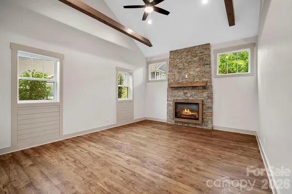 a view of an empty room with window and a fireplace