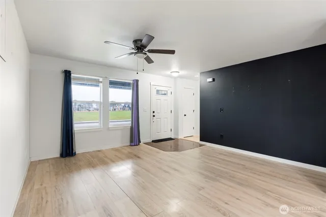 a view of a kitchen with wooden floor and a ceiling fan