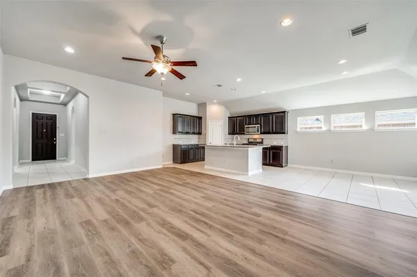 a view of a kitchen with a stove cabinets wooden floor and a ceiling fan