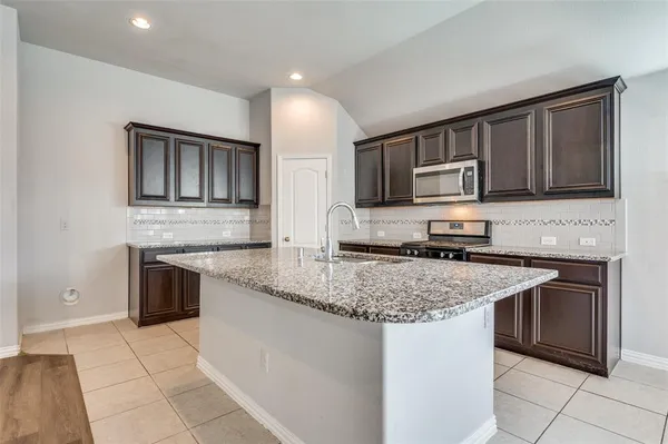 a kitchen with stainless steel appliances granite countertop a sink stove and microwave