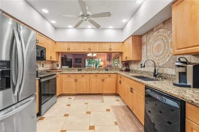 a kitchen with stainless steel appliances granite countertop a sink counter space cabinets and a large window