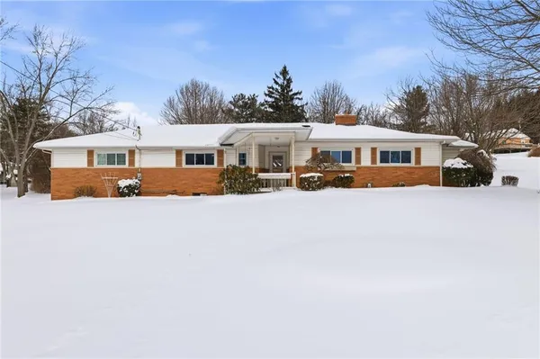a front view of house with yard and trees in the background