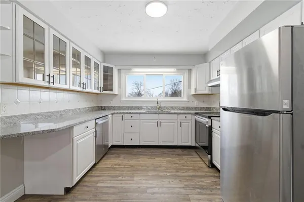 a kitchen with a refrigerator sink and cabinets