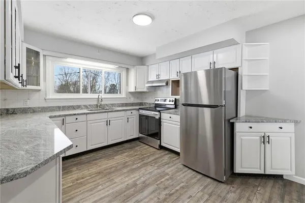 a kitchen with white cabinets and white appliances