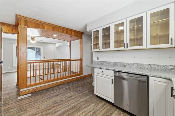 a view of a granite countertop cabinets and wooden floor