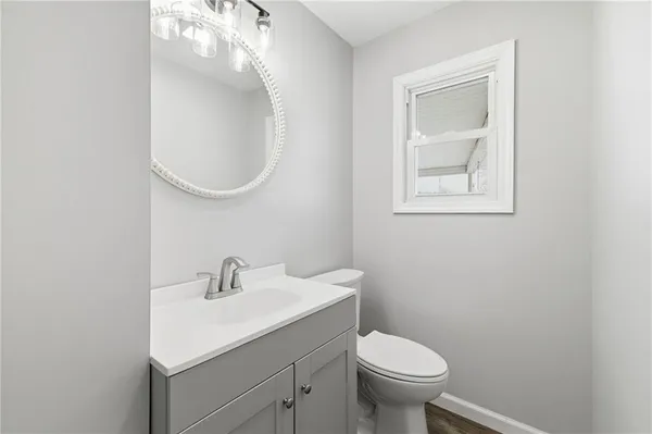 a bathroom with a toilet a sink and mirror
