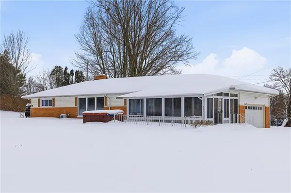 a view of a house with a yard covered in snow