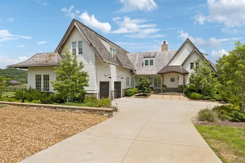 a front view of a house with yard and trees