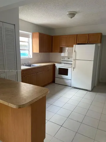 a kitchen with stainless steel appliances granite countertop a sink and a stove