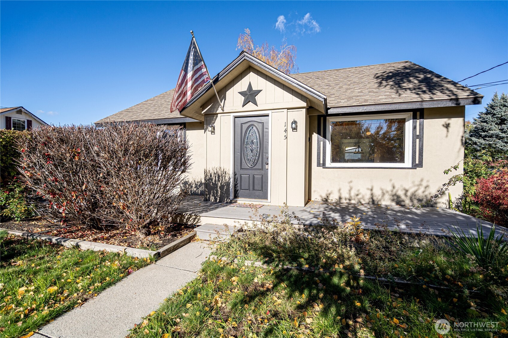 145 North Harris Avenue Manson, WA 98831 - Photo 2 of 28 a front view of a house with a yard and garage