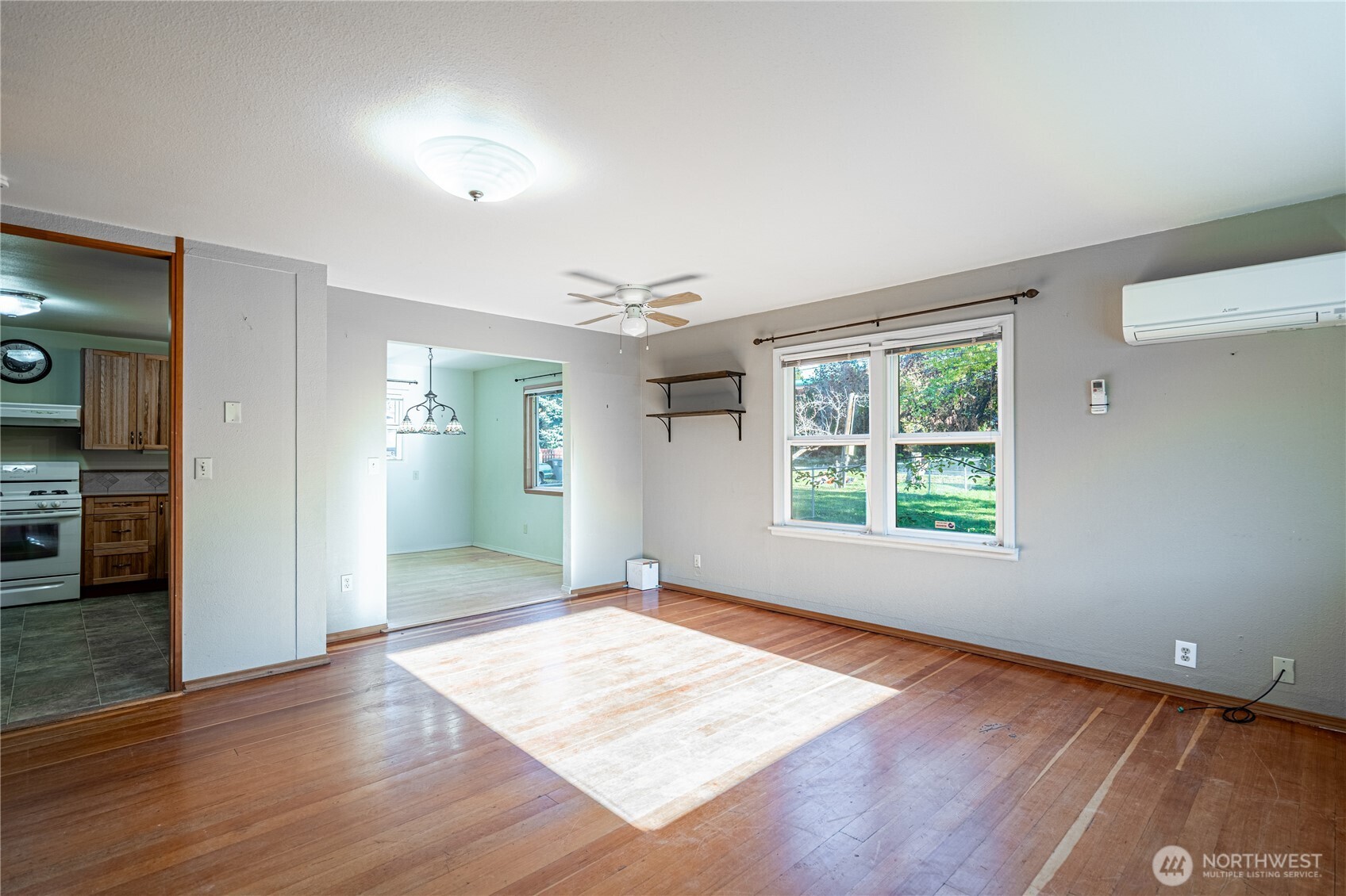 145 North Harris Avenue Manson, WA 98831 - Photo 4 of 28 an empty room with wooden floor and windows
