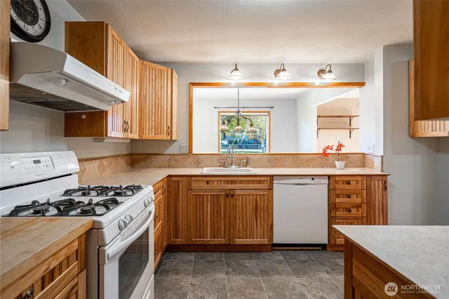 a kitchen with granite countertop a sink stove and cabinets