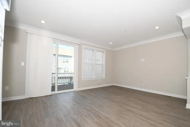 a view of a big room with wooden floor and windows