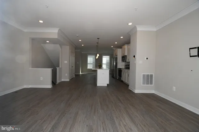 a kitchen with stainless steel appliances kitchen island a sink a stove a refrigerator and cabinets