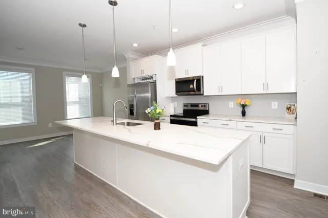 a kitchen with stainless steel appliances a refrigerator sink and stove