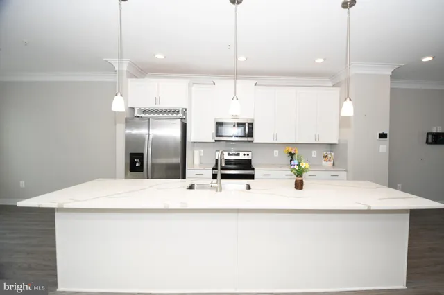 a large kitchen with kitchen island a sink stainless steel appliances and cabinets