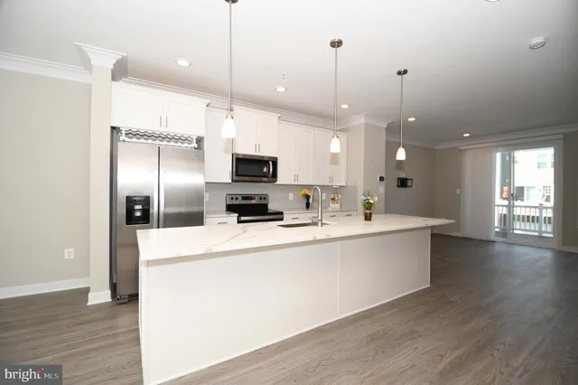 a kitchen with stainless steel appliances a refrigerator a stove a microwave and cabinets