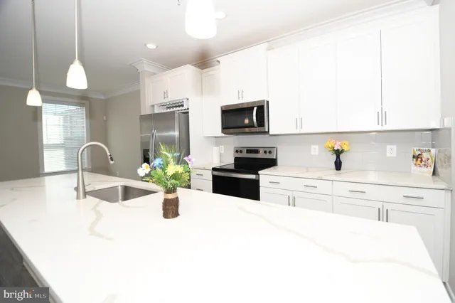 a large kitchen with a lot of counter top space and stainless steel appliances