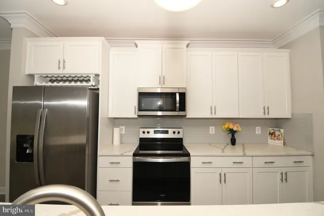 a view of a big room with wooden floor and a kitchen