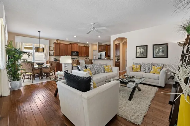 a living room with furniture a clock and a flat screen tv