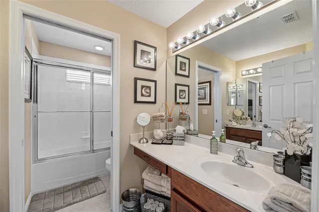 a bedroom with a bed and a large mirror on the dresser