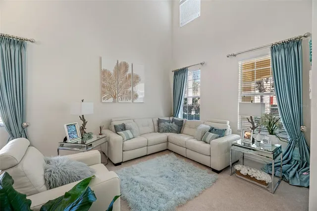 a living room with furniture a potted plant and a large mirror