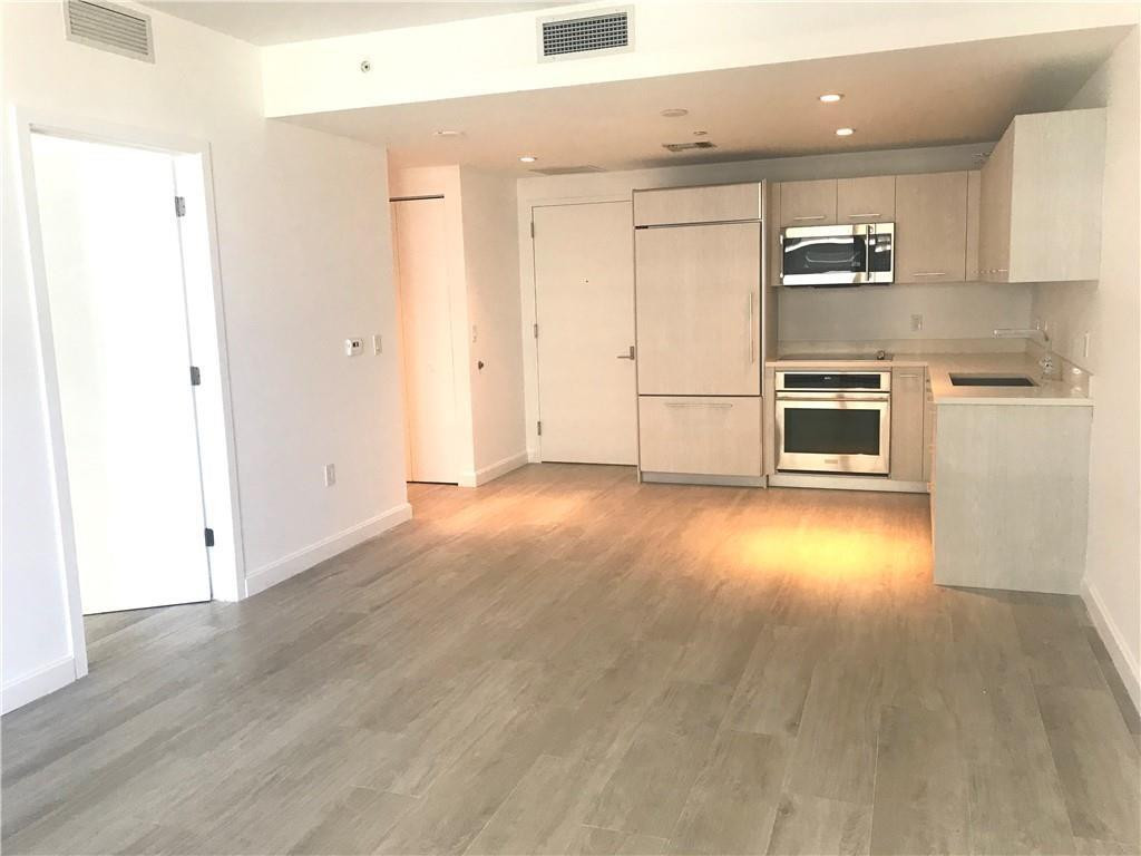 45 Southwest 9th Street, Unit 3707 Miami, FL 33130 - Photo 24 of 29 a view of a kitchen with wooden floor and electronic appliances