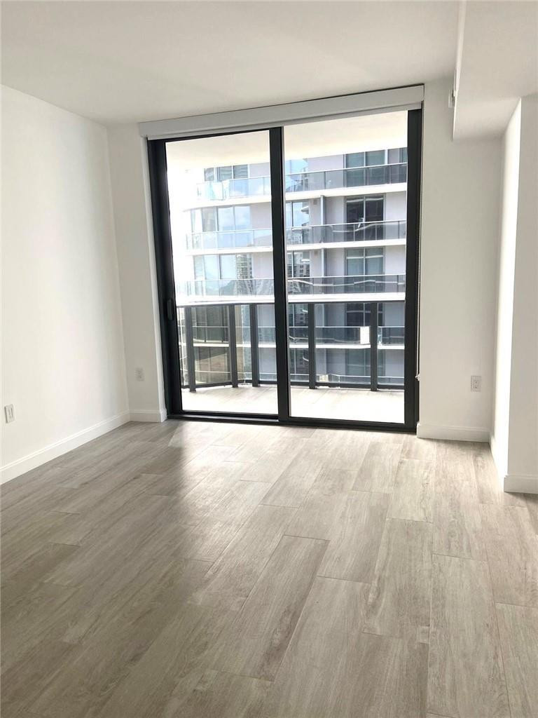 45 Southwest 9th Street, Unit 3707 Miami, FL 33130 - Photo 5 of 29 an empty room with wooden floor and windows