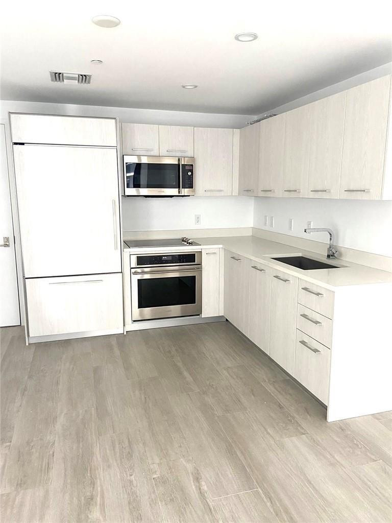 45 Southwest 9th Street, Unit 3707 Miami, FL 33130 - Photo 6 of 29 a kitchen with stainless steel appliances granite countertop a stove top oven a sink a refrigerator a microwave and white cabinets