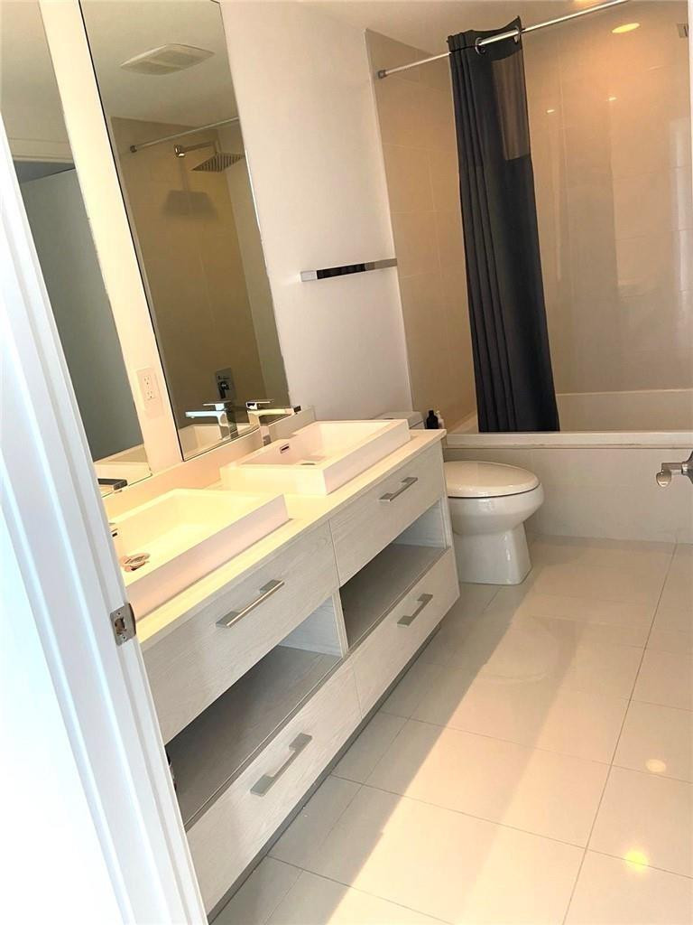 45 Southwest 9th Street, Unit 3707 Miami, FL 33130 - Photo 7 of 29 a bathroom with a sink a toilet and a mirror