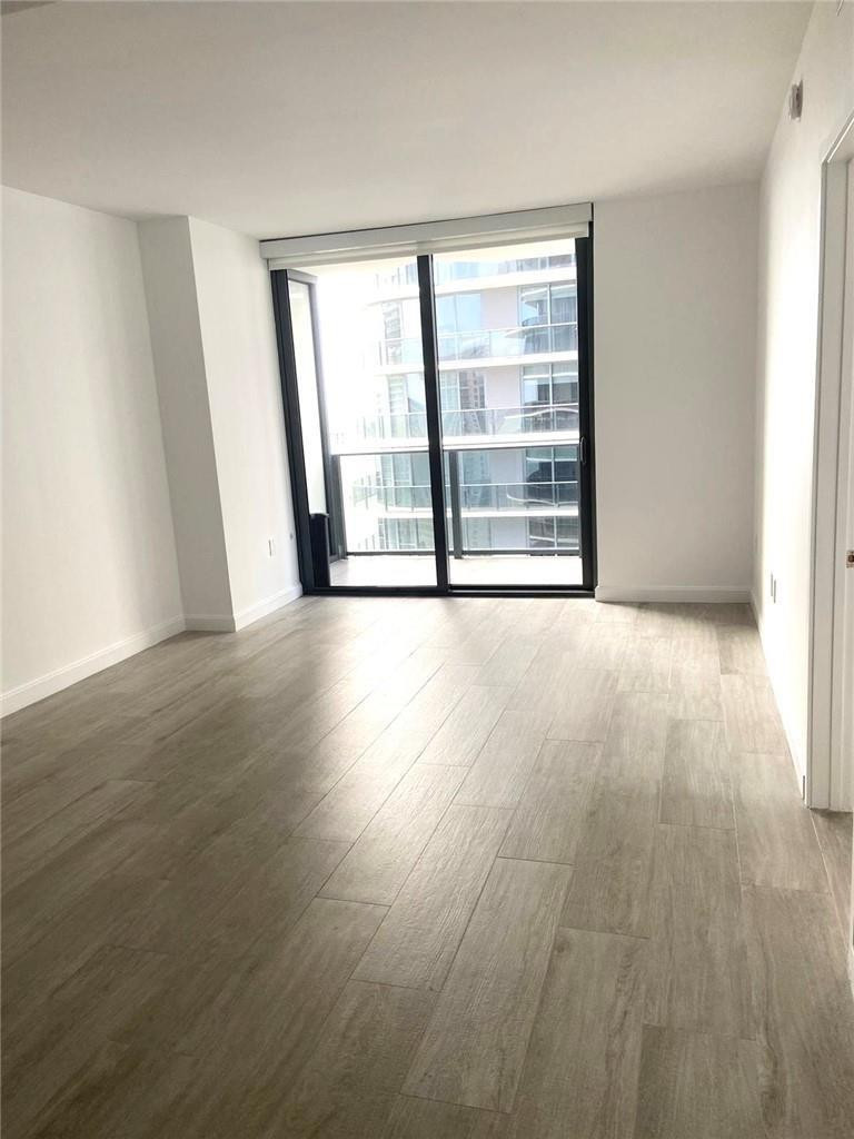 45 Southwest 9th Street, Unit 3707 Miami, FL 33130 - Photo 8 of 29 a view of an empty room with wooden floor and a window