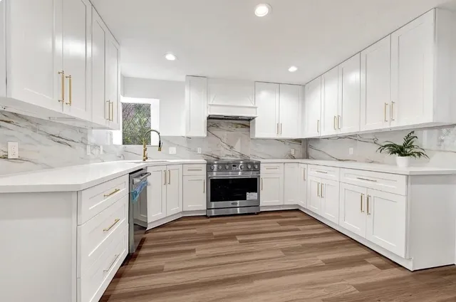 a kitchen with granite countertop white cabinets and white stainless steel appliances