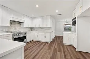 a kitchen with white cabinets and appliances
