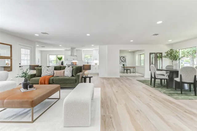 a living room with furniture wooden floor and a large window