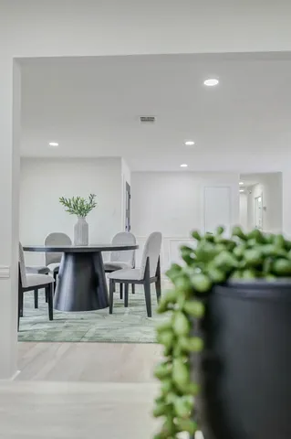 a kitchen with stainless steel appliances a dining table chairs and sink
