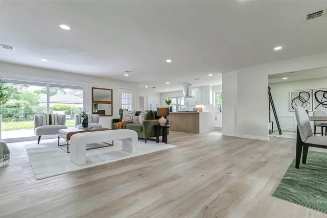 a living room with furniture and a dining table with kitchen view