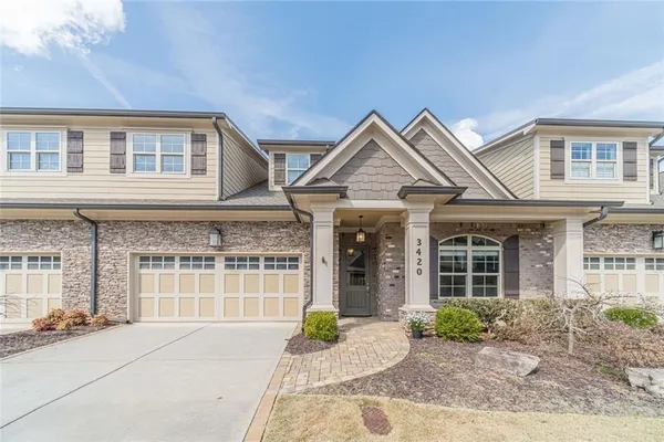 a front view of a house with a yard and potted plants