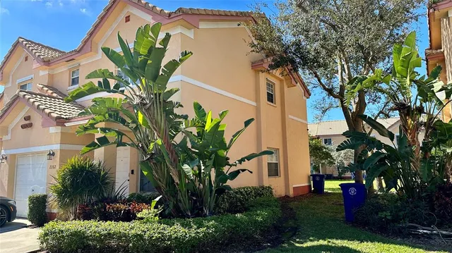 a front view of a house with a tree