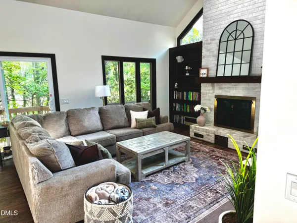 a living room with furniture a flat screen tv and a fireplace
