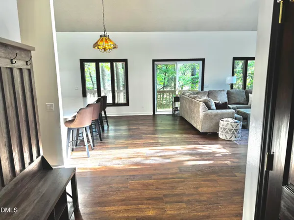a living room with furniture a fireplace and floor to ceiling window